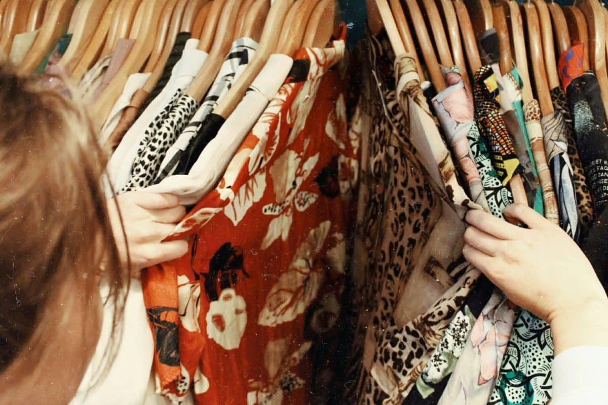 Femme cherchant vêtements sur des cintres